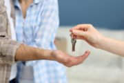 woman’s hand handing new apartment keys to male hand