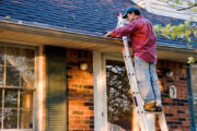 cleaning gutters, man on ladder, rental property maintenance