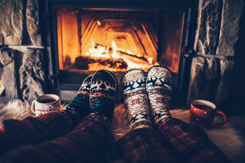 Two people sitting in front of fire, socks, mugs – How to make holiday renters welcome
