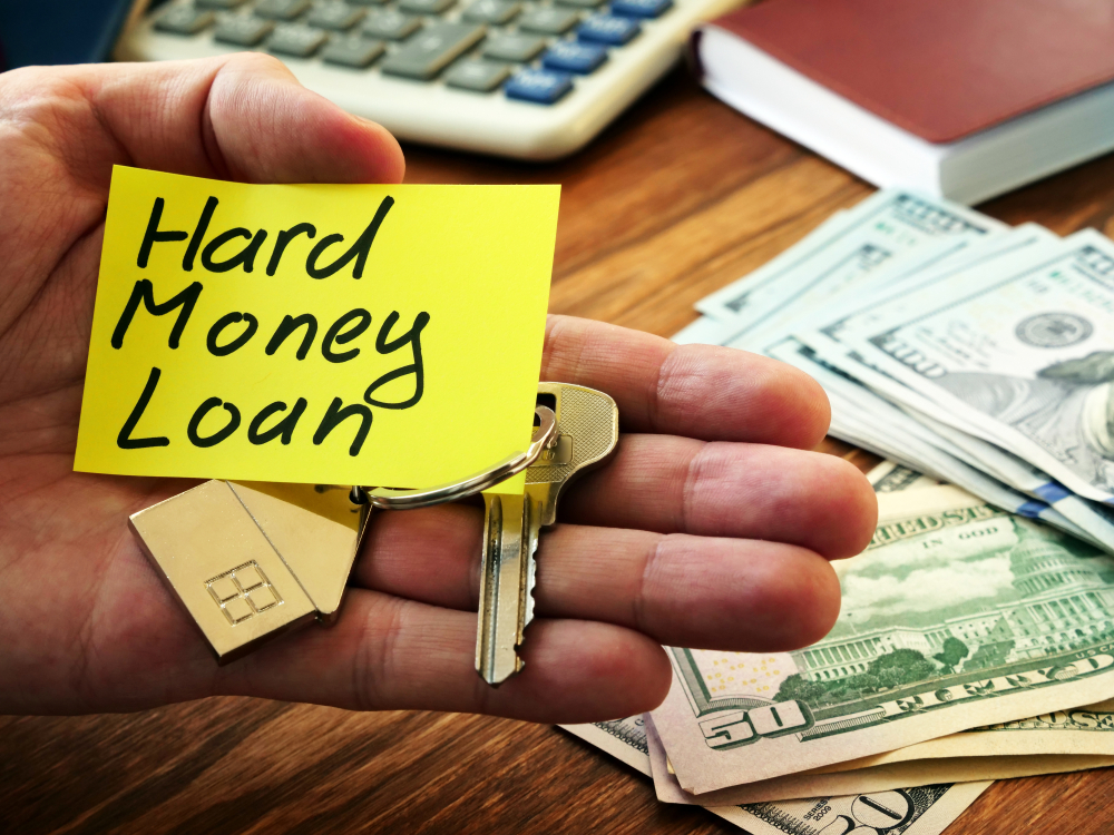 hand holding hard money loan sign, key, money, calculator