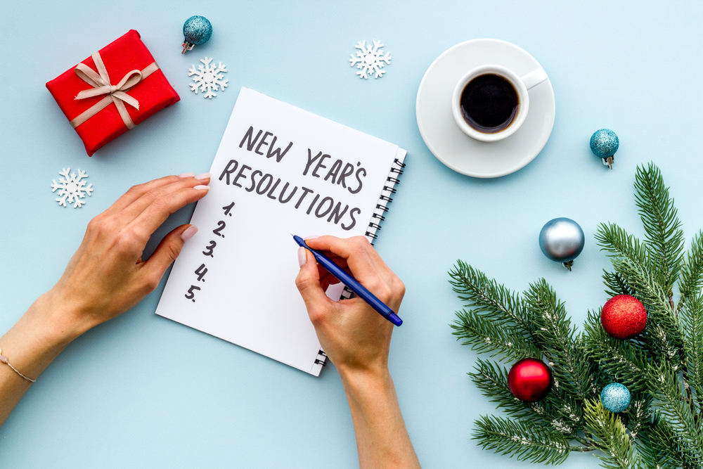 person writing new years resolution list, holiday decor
