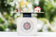 scale with coins, miniature house, balancing, property value