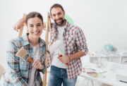 smiling couple renovating home, house flipping